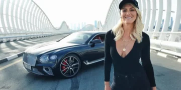 Prabangus sportinis automobilis su durimis, atsidarančiomis į viršų, Dubajaus fone