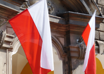 Lenkijos ir Rusijos vėliavos simboliškai priešpriešoje, iliustruojančios įtemptus santykius