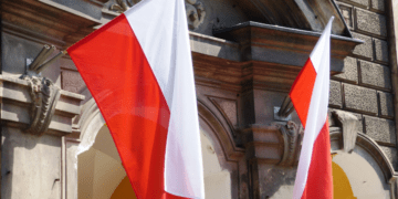 Lenkijos ir Rusijos vėliavos simboliškai priešpriešoje, iliustruojančios įtemptus santykius
